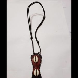 Two cowrie shells on brown leather